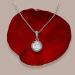 Prosperity pendant necklace resting gently on a red rose petal.