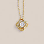 18k gold-plated Radiance necklace featuring a round-cut cubic zirconia crystal surrounded by intertwining loops that resemble a Celtic knot with embedded crystals.